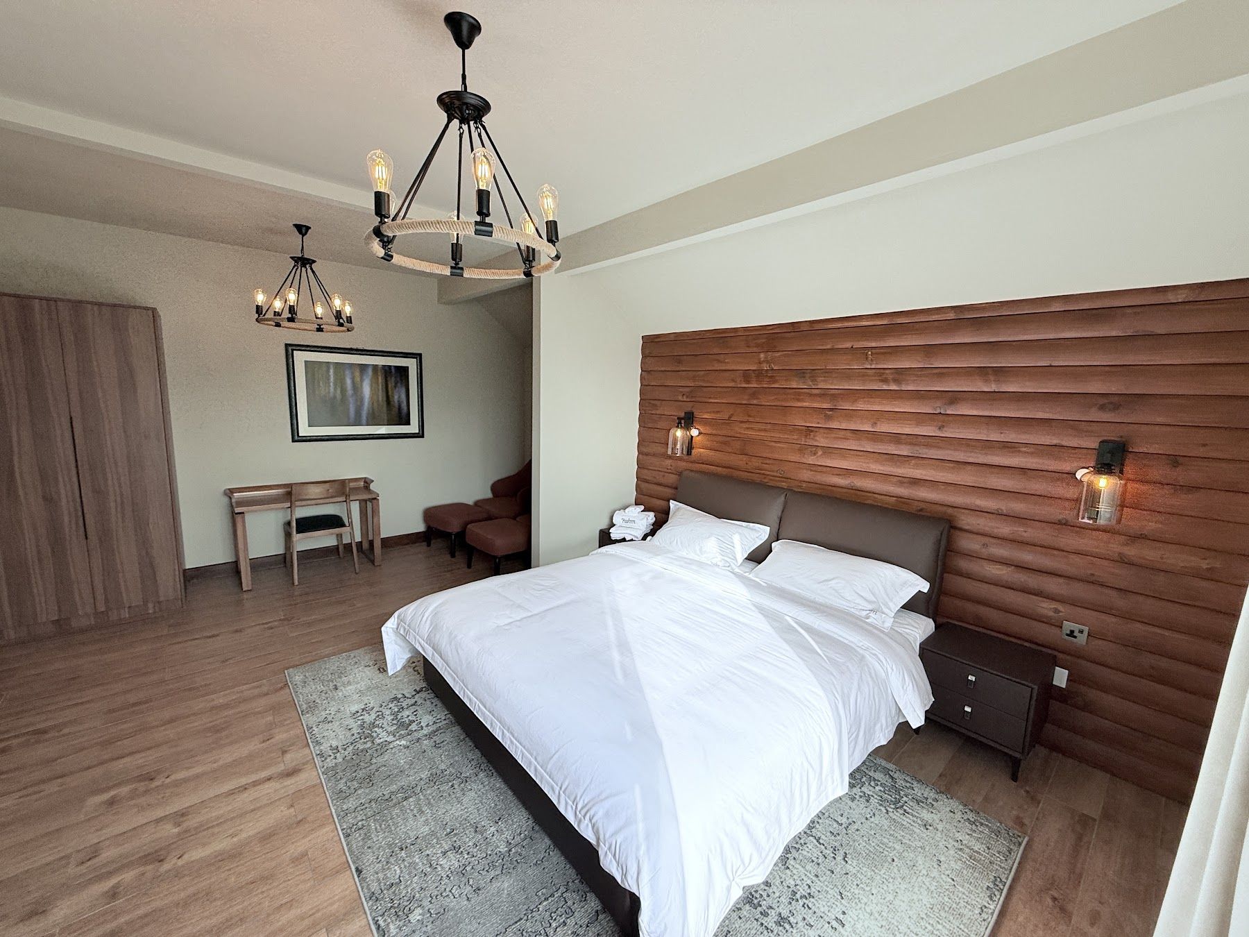 Lodge room with timber wall, king bed and iron chandelier